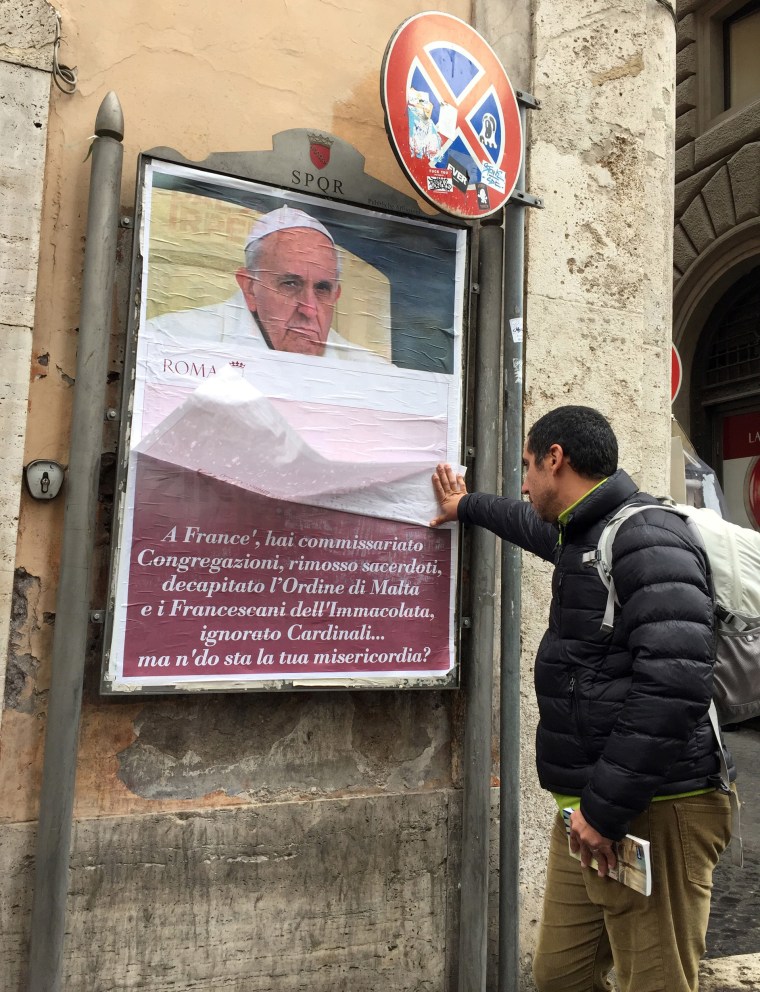 Image: A passerby lifts a paper sheet covering an anti-Pope Francis poster to read it, in central Rome, Italy, Feb. 4, 2017.
