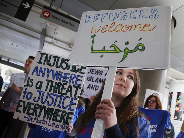 A woman holds a sign saying "welcome" in English and Arabic as demonstrators opposed to President Donald Trump's executive orders barring entry to the U.S. by Muslims from certain countries protest at the Tom Bradley International Terminal at Los Angeles International Airport on Saturday, Feb. 4, 2017.