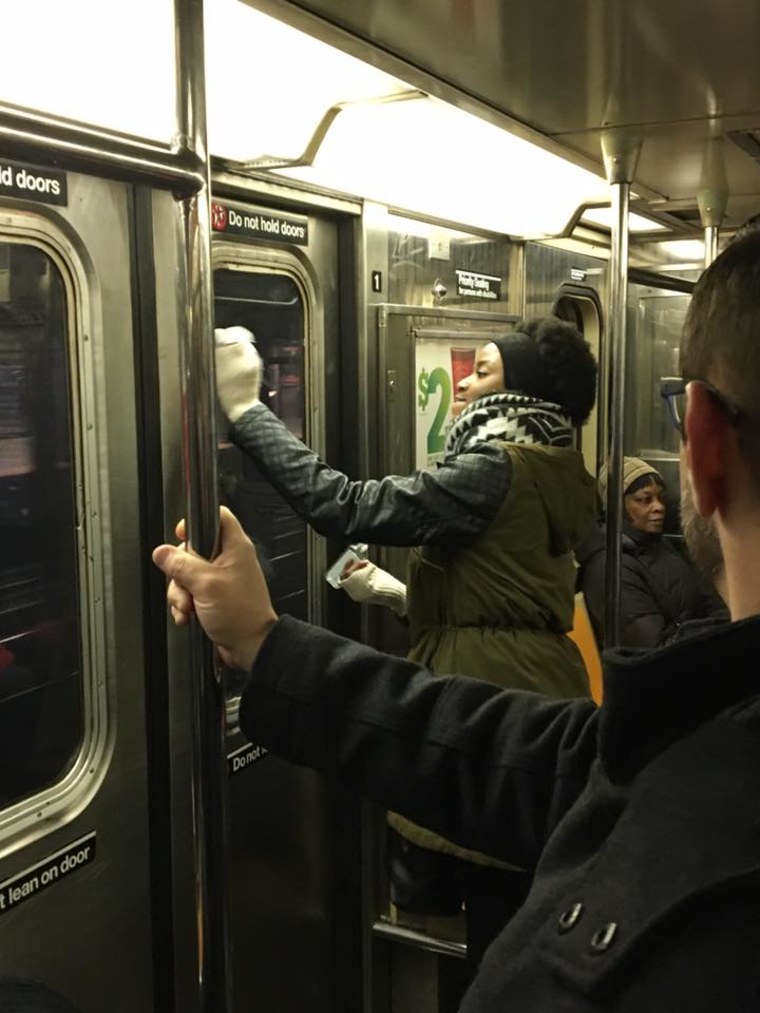 Image: Passengers scrub anti-Semitic graffiti off of a New York City Subway car