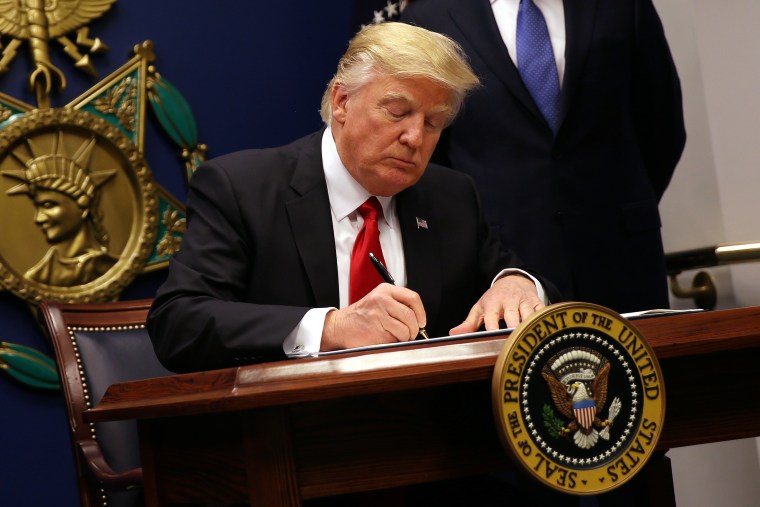 Image: U.S. President Donald Trump signs an executive order to impose tighter vetting of travelers entering the United States, at the Pentagon in Washington