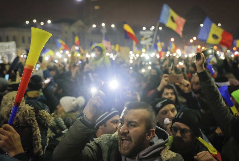 Image: Tens of thousands shine lights from mobile phones and torches during a protest in front of the government building in Bucharest, Romania.