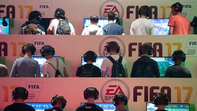 Visitors playing the game FIFA 17 at the EA Sports stall at the Gamescom gaming convention on August 18, 2016 in Cologne, Germany.