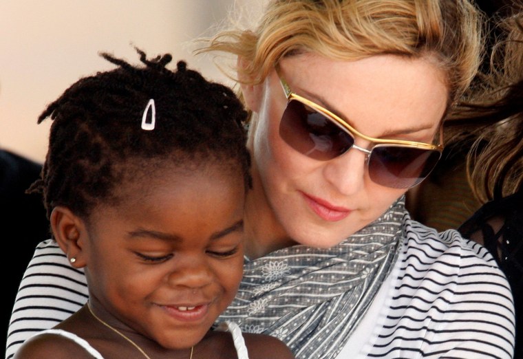 Image: FILE PHOTO: Madonna sits with her adopted Malawian child Mercy James during a bricklaying ceremony at the site of her Raising Malawi Girls Academy