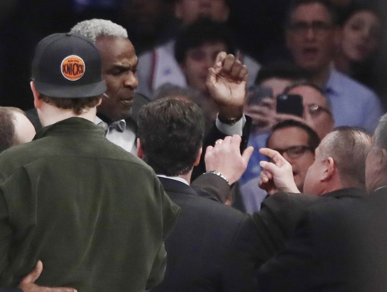 Image: Charles Oakley exchanges words with a security guard during the first half of an NBA basketball game