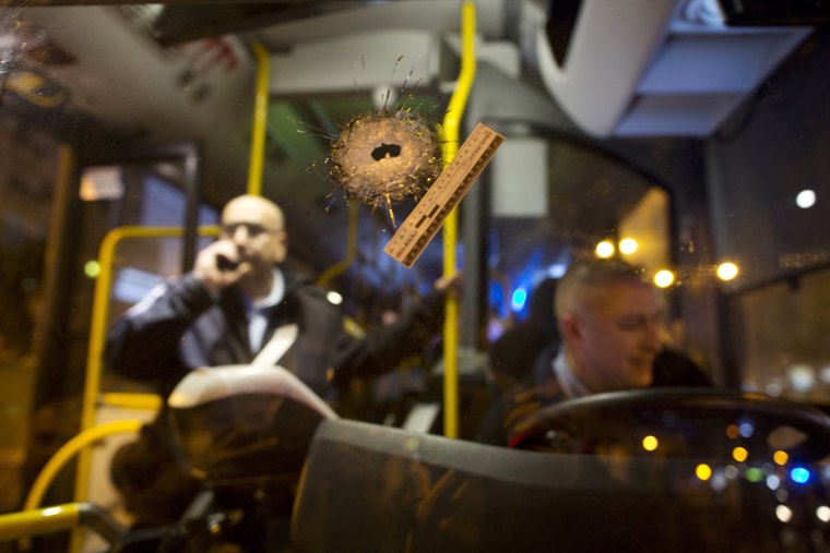 Image: A bullet hole is seen on the windshield of a bus at the scene of a shooting attack in Petah Tikva