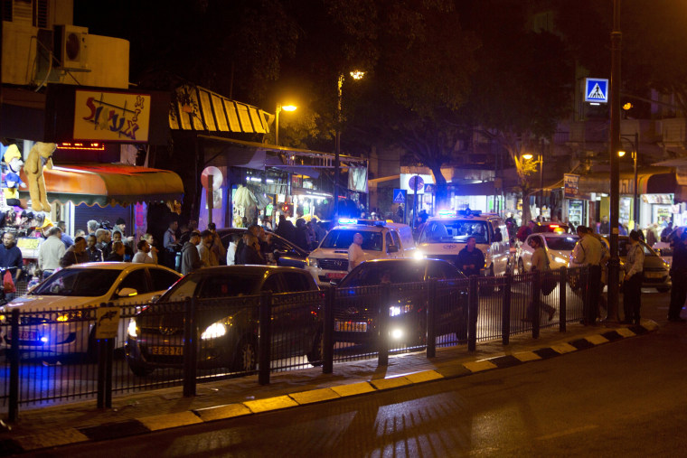 Image: Israeli police officers inspect the scene of a shooting attack in Petah Tikva