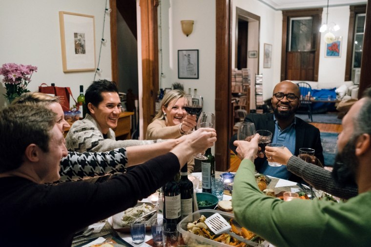 Image: A group of strangers gather for dinner as a part of the #100Days100Dinners initiative that unites people from opposing ideologies for an evening of food drinks and relationship building.