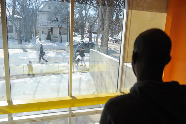 Image: A refugee claimant from Djibouti looks out the window of the Manitoba Interfaith Immigration Council shelter