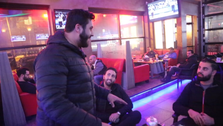 Image: Moe Qasim jumps into a conversation at the Signature Cafe hookah lounge