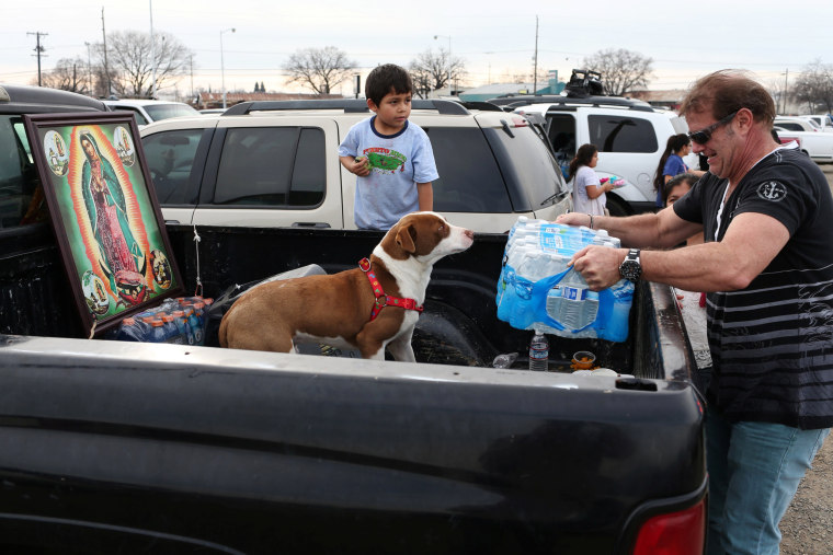 Image: Richard Kelly, of Chico, distributes water at a Red Cross relief center in Chico, California, after an evacuation was ordered for communities downstream from the Lake Oroville Dam, in Oroville