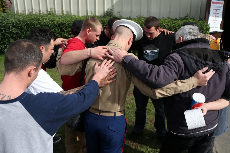 Image: Members of the Jordan Crossing Ministry of Oroville, California, pray for Marine Russell Bluxome at a Red Cross relief center in Chico, California