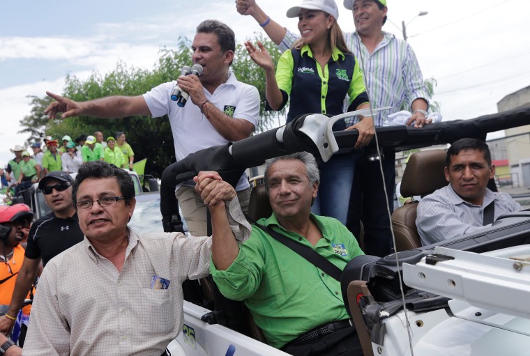 Image: Lenin Moreno, presidential candidate from the ruling PAIS Alliance party, poses with a a supporter during a campaign rally along the streets in Babahoyo