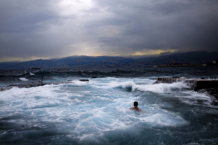Image: A swimmer goes for an early morning dip in the Mediterranean sea
