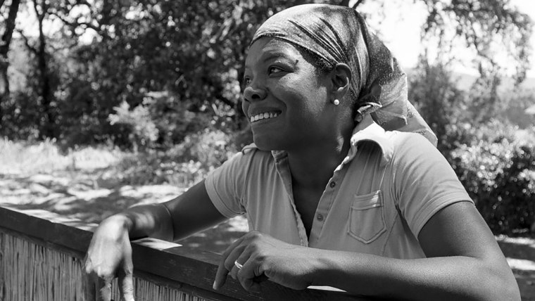 Dr. Maya Angelou leaning against a fence.