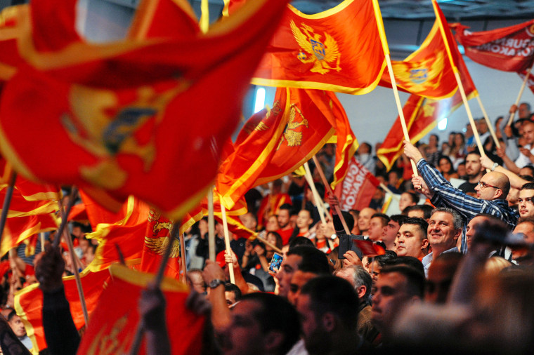 Image: Supporters of Montenegrin Prime Minister Milo Djukanovic wave flags during an election rally in Podgorica