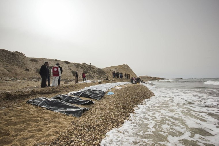 Image: Volunteers recover the bodies of 74 people near Zawiya, Libya