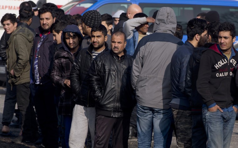Image: Migrants line up to buy food 