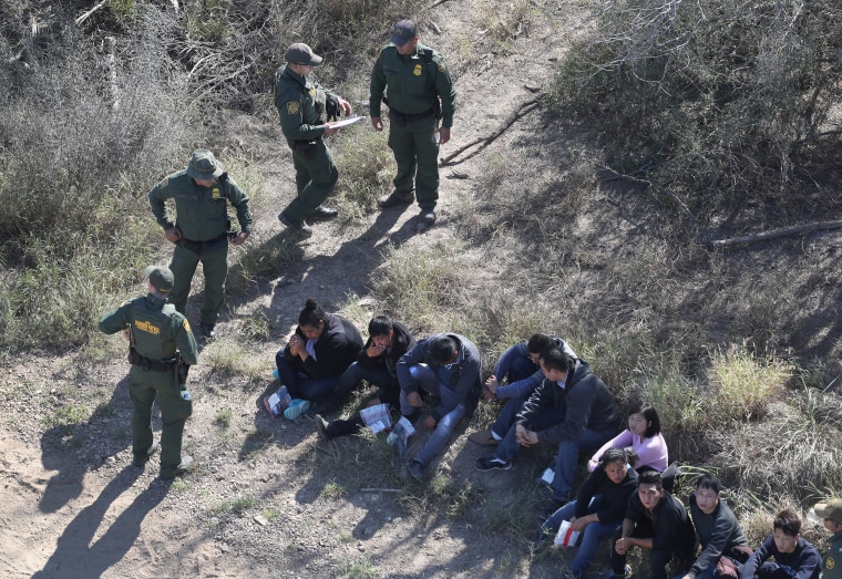 Image: U.S. Border Patrol agents watch over immigrants who crossed the U.S.-Mexico border