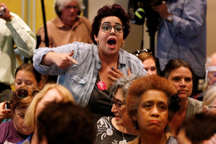 Image: A woman shouts during a town hall meeting for Republican U.S. Senator Bill Cassidy in Metairie