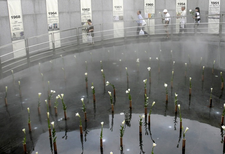Image: Relatives of victims of "White Terror" hold lilies as they walk past a pond full of lilies during a memorial to mark the 22nd anniversary of the end of martial law, in Taipei, July 15, 2009.
