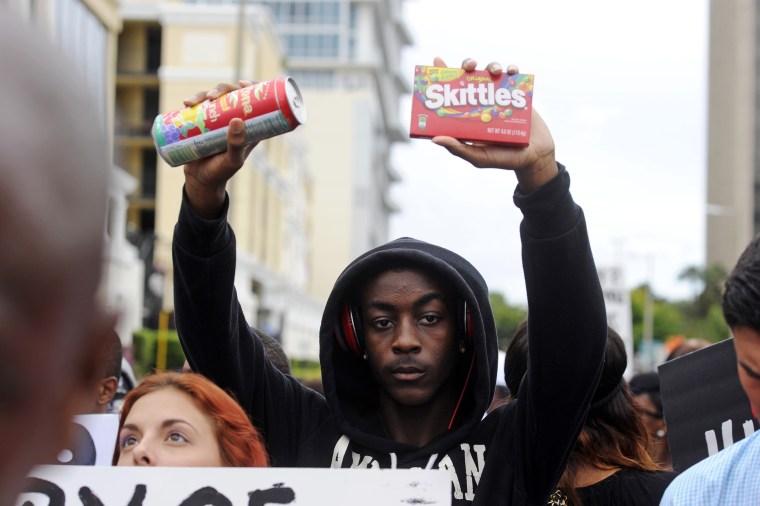 Image: Brendon Daniels holds up a can of iced tea and a bag of skittles during a rally in support of slain teenager Trayvon Martin in Orlando, Florida, July 17, 2013.