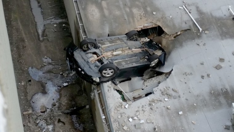 Image: A vehicle drove off a parking garage and landed in a building below Sunday afternoon, Feb. 26, 2017, Houston, Texas.