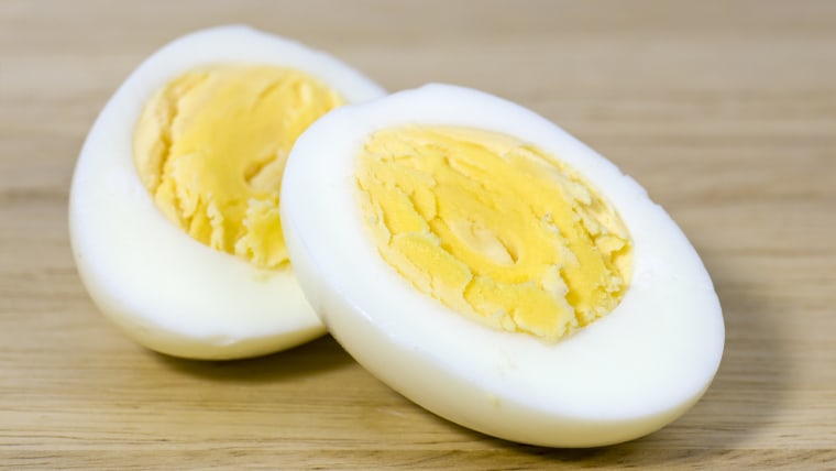 Hard boiled egg cut in half on chopping board