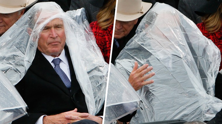 Former President George W. Bush uses a plastic sheet to deal with the rain during the inauguration ceremonies swearing in Donald Trump