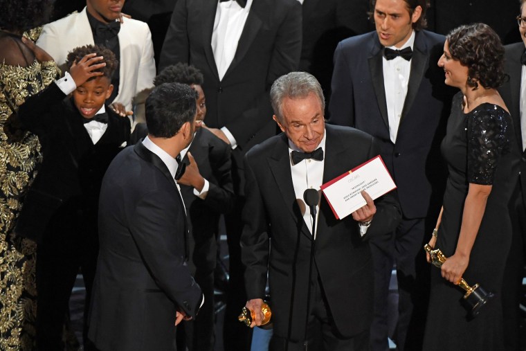 Image: Warren Beatty shows the winner's envelope for best picture on stage