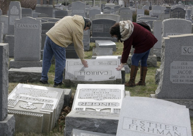 Image: Joe Nicoletti and Ronni Newton of the Taconey Holmesburg town watch group pay their respects at a damaged headstone in Mount Carmel cemetery, Feb. 27, 2017, in Philadelphia.