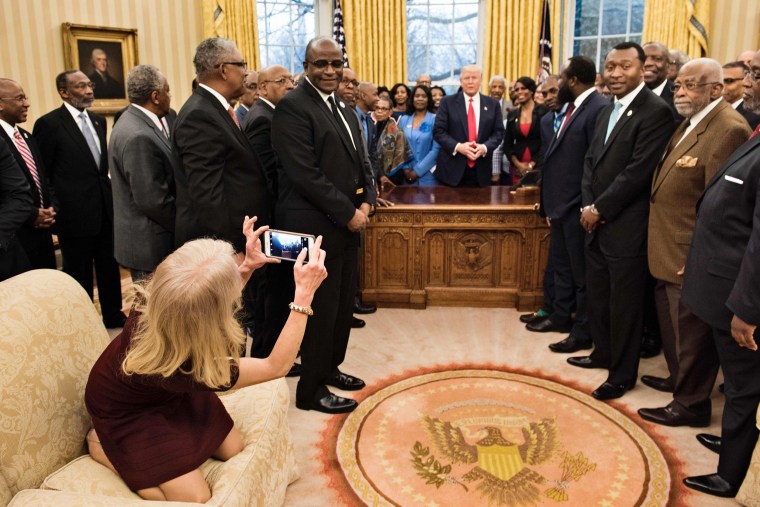 Image: Kellyanne Conway takes a photo in the Oval Office