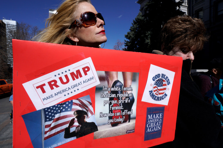 Image: A supporter of U.S. President Donald Trump holds a sign at a \"Spirit of America\" rally in Denver