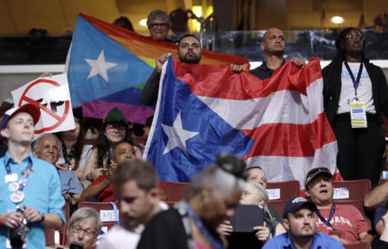 Puerto Rico delegates hold up flags during the first day of the Democratic National Convention in Philadelphia , Monday, July 25, 2016.