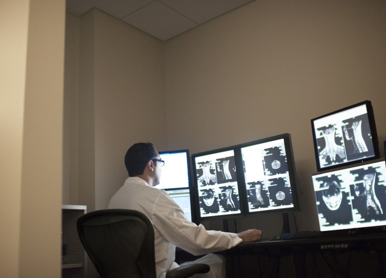 Radiologist checks X rays on multiple computer scr