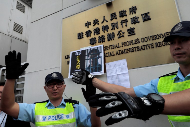 Image: Police react in front of disbarred lawyer Jiang Tianyong's portrait