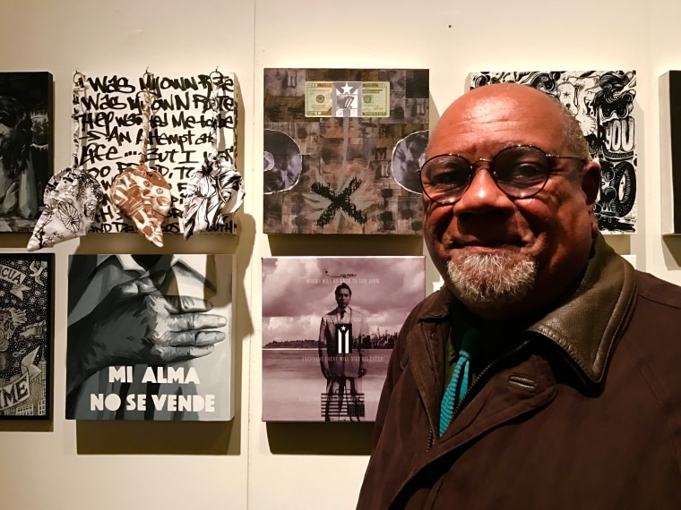 Artist Juan Sanchez stands next to his piece "Economicamente esclavos."