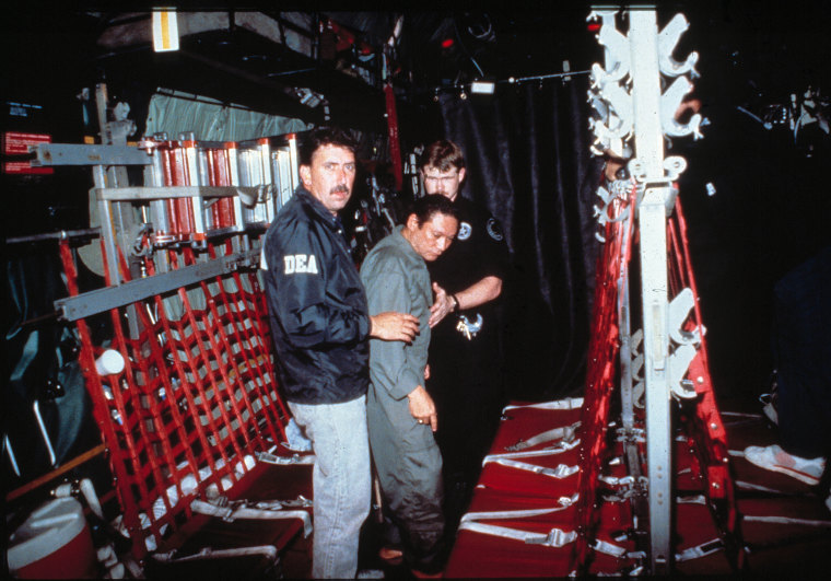 Image: U.S. Drug Enforcement Agents help Manuel Antonio Noriega into a C-130 transport plane en route from Panama City to Miami