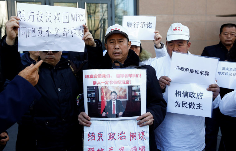 Image: Relatives of missing passengers hold up placards Wednesday outside the foreign ministry in Beijing, China.