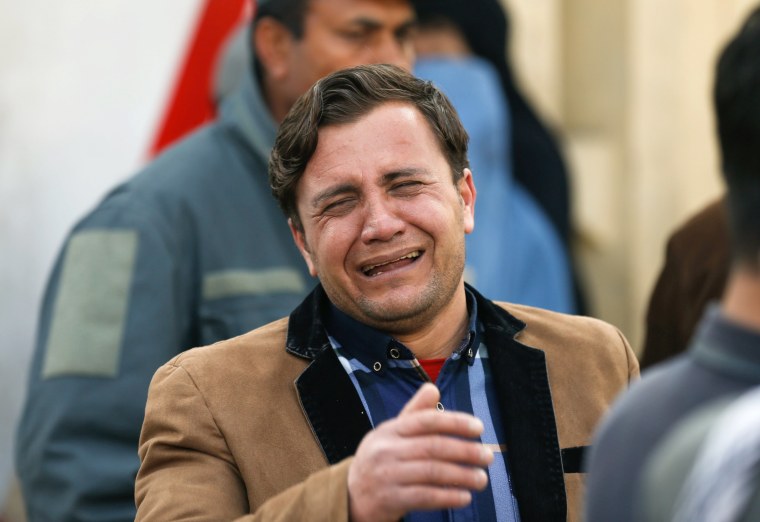 Image: An Afghan man cries outside a military hospital at the site of blast and gunfire in Kabul