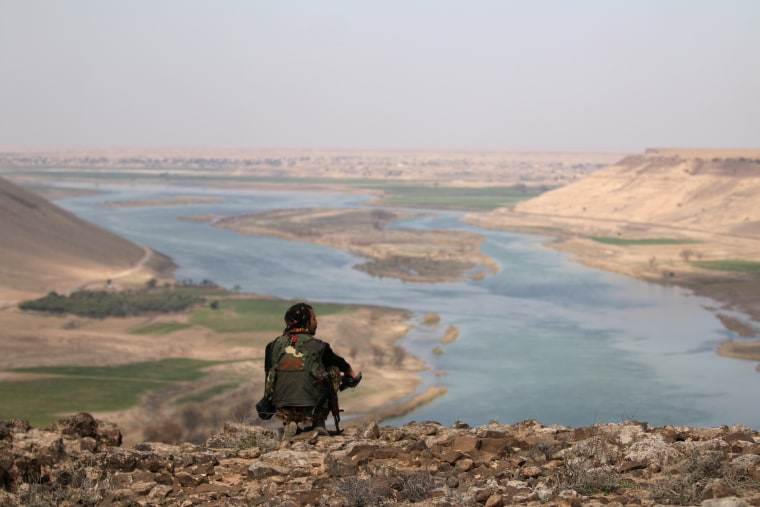 Image: A Syrian Democratic Forces (SDF) fighter rests while looking over the Euphrates River north of Raqqa.