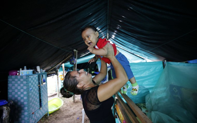 Image: Jerly Suarez holds up her 9-month-old son Dainer