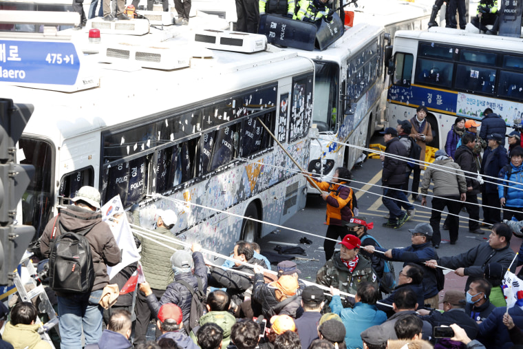 Image: Supporters of the president clash with policemen as they attempt to pass the barricade of police buses towards the Constitutional Court in protest after the court's ruling.