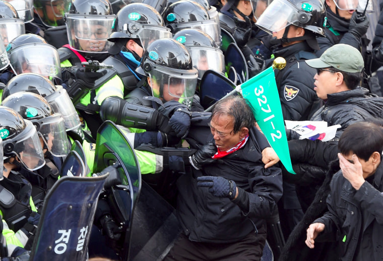 Image: Supporters of Park Geun-hye clash with police after the announcement of the Constitutional Court. The rival crowds outside South Korea's court show the opposing passions and generational splits over the country's sweeping political scandal.