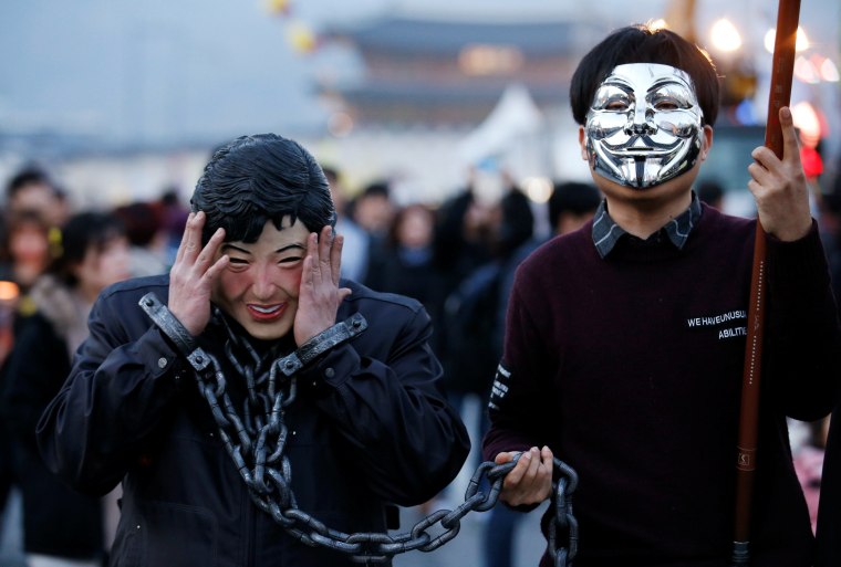 Image: A protester in a mask depicting South Korea's ousted leader Park Geun-hye wears shackles at a rally against Park in Seoul