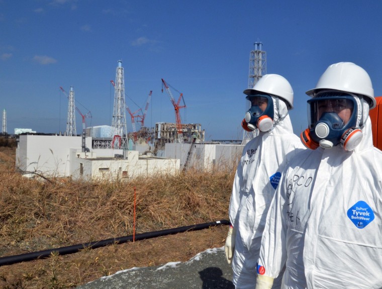 Image: Workers stand in front of the stricken Fukushima Daiichi nuclear power plan