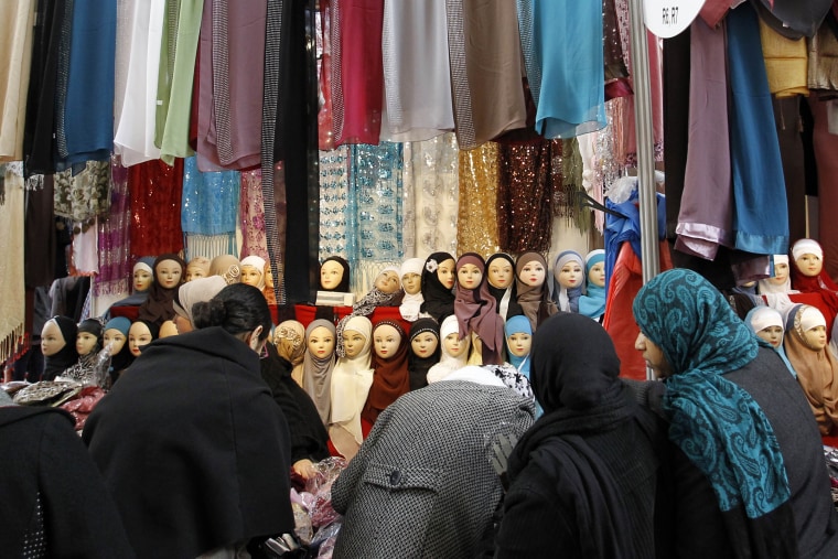 Image: Women look at veils on display 