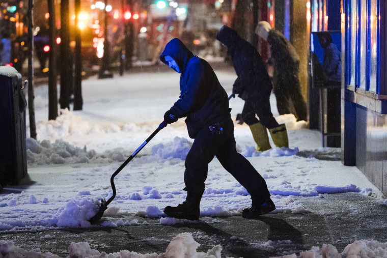Image: Workmen clear a sidewalk during a winter storm in Philadelphia