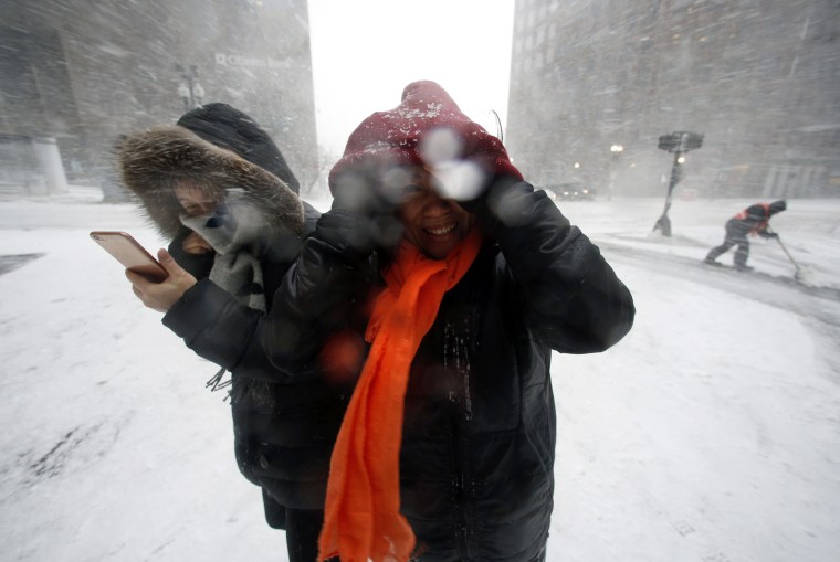 Image: People walk in the wind-driven snow during a winter storm