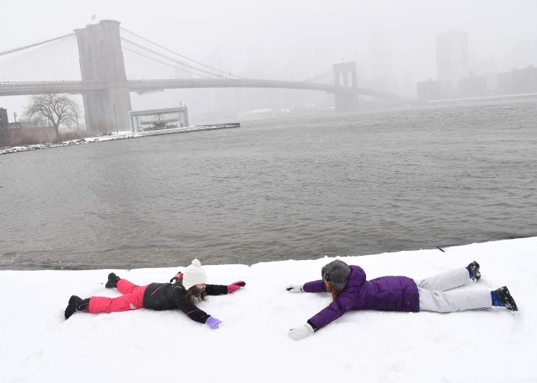 Image: Two girls make snow angels in Brooklyn Bridge Park