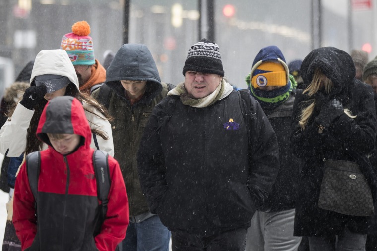 Image: A tourist group walks through the snow and wintry mix in New York